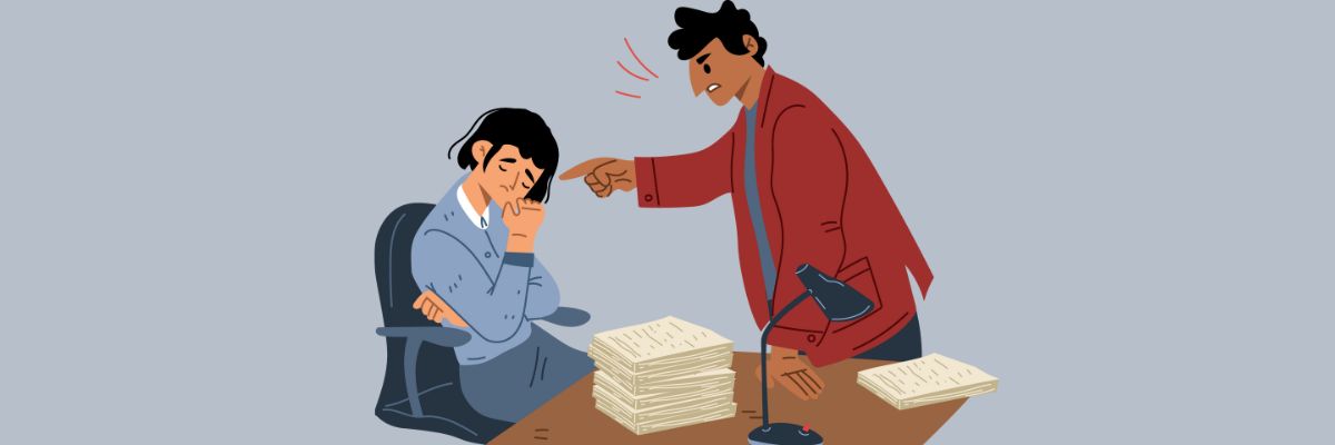 Altext: An illustration of a frustrated boss pointing and yelling at a stressed employee sitting at a desk piled with papers.