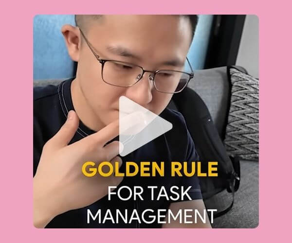 A man wearing glasses sits on a couch and appears to be thinking or speaking, with the overlaid text reading "Golden Rule for Task Management." A play button icon is centered on the image, suggesting it's a video.