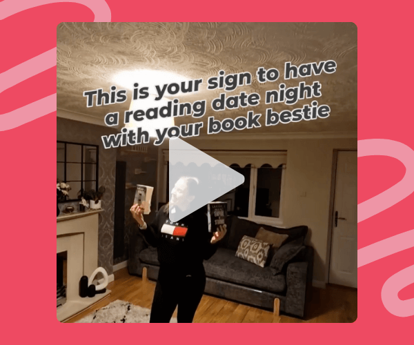 Screenshot of a cozy living room with a woman holding up two books, overlaid with the text “This is your sign to have a reading date night with your book bestie.”