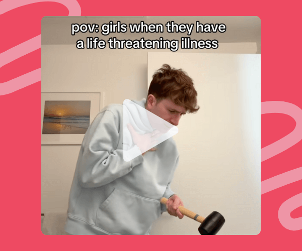 A man in a light hoodie dramatically clutching his chest with one hand and holding a rubber mallet in the other, with the caption "pov: girls when they have a life threatening illness." The background has a framed photo and white walls. The image has a pink border.