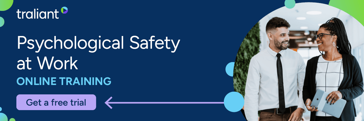 A banner promoting “Psychological Safety at Work” online training by Traliant, featuring a smiling man and woman walking together in a professional setting. The text invites viewers to “Get a free trial,” with a bright, modern design in navy blue, green, and purple accents.