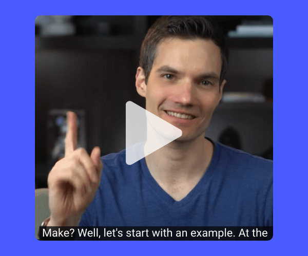 A smiling man in a blue shirt is sitting indoors and holding up one finger while looking at the camera. There's a large translucent play button over the image, indicating it’s a video thumbnail, and the caption at the bottom reads, “Make? Well, let's start with an example. At the…”