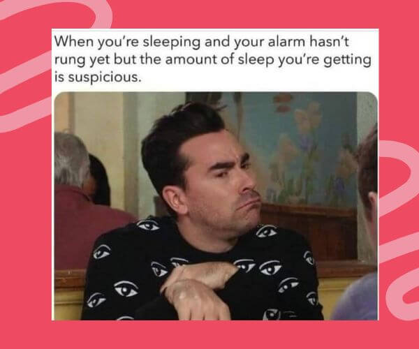 Meme of a man with a suspicious side-eye expression, wearing a black shirt with eye patterns. The caption jokes about waking up before the alarm goes off and feeling like you’ve slept too long.