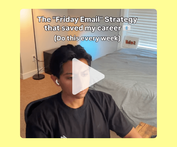 The image shows a person sitting at a desk at home, wearing earbuds, with a neatly made bed, a floor lamp, and soft natural light filling the room behind them. Text on the image reads: “The ‘Friday Email’ Strategy that saved my career (Do this every week).”