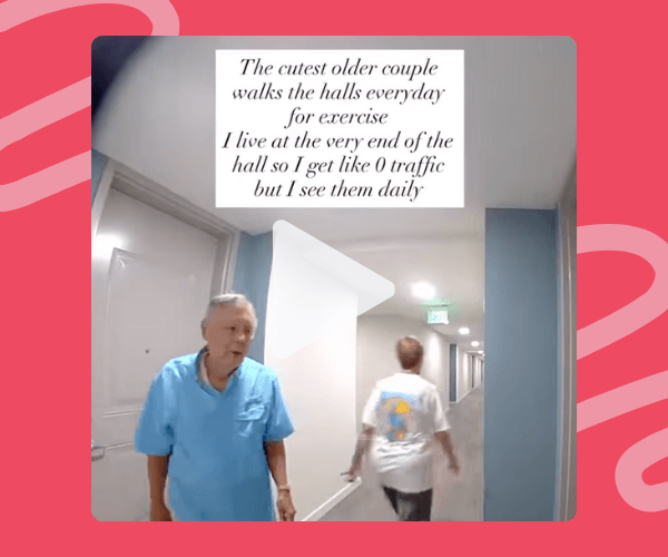 Screenshot from a short video showing an older couple walking down a quiet apartment hallway, with on-screen text explaining they walk the halls every day for exercise.