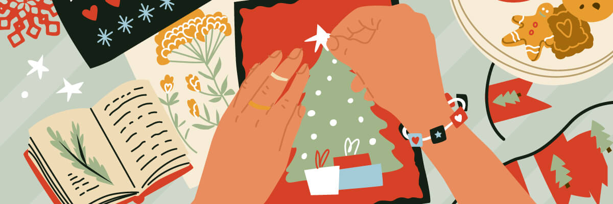Illustrated hands decorate a small green Christmas tree card, placing white dots and stickers, surrounded by an open book, flowers, and holiday crafts. The muted green and red background is filled with festive patterns, cozy textures, and seasonal details.
