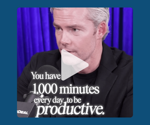 Screenshot from a podcast-style video of a man speaking into a microphone, set against a deep purple curtain background. White text over the video reads, “You have 1,000 minutes every day to be productive,” framed within a dark blue overlay.