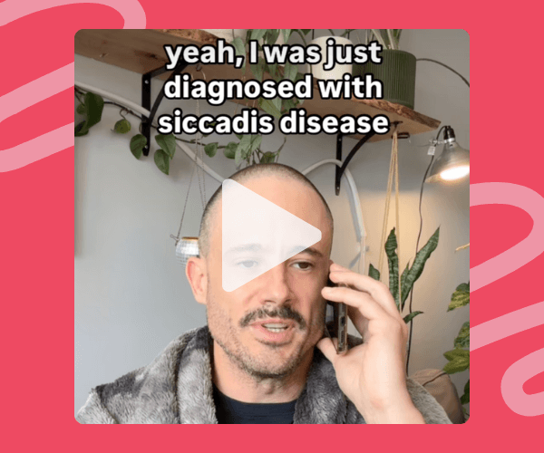 Screenshot from a video of a man on the phone with on-screen text reading, âyeah, I was just diagnosed with siccadis disease.â Heâs indoors with lots of houseplants and shelves behind him.