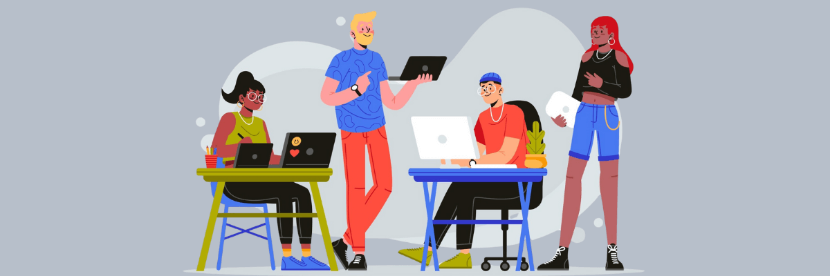 Illustration of a diverse group of coworkers working together, some seated at desks and others standing with laptops and tablets. The casual outfits, shared workspace, and relaxed body language give it a modern, collaborative office vibe.