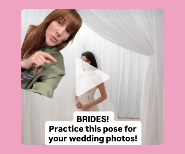 Video still of a woman pointing toward the camera while another woman in a wedding dress stands in the background, with on-screen text that reads: “BRIDES! Practice this pose for your wedding photos!”