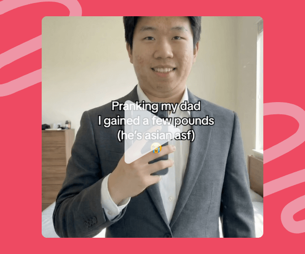 Video still of a man in a suit taking a mirror selfie, with on-screen text that reads: “Pranking my dad I gained a few pounds (he’s asian asf)” with a laughing emoji.