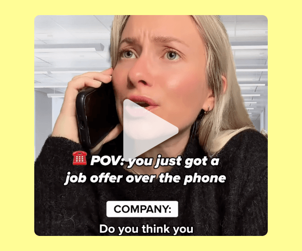 A close-up of a woman holding a phone to her ear with a concerned expression, with a play button overlay. Text on the image references receiving a job offer over the phone.