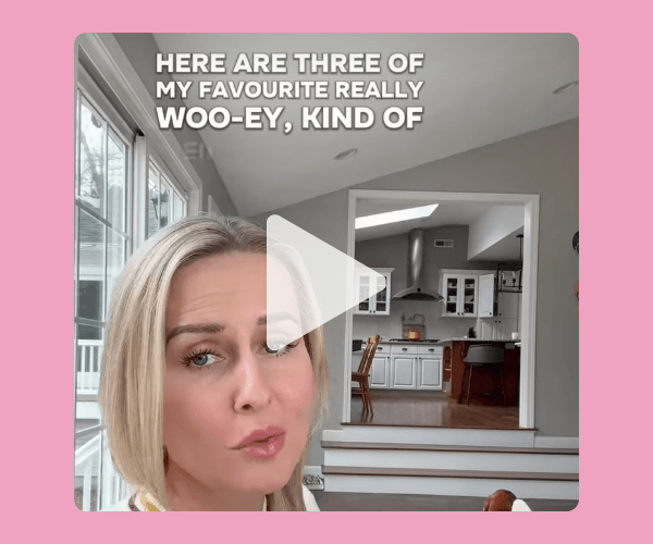 A blonde woman looks toward the camera mid-sentence inside a bright home with a kitchen in the background. A play button overlay sits over text that begins, “Here are three of my favourite really woo-ey…”