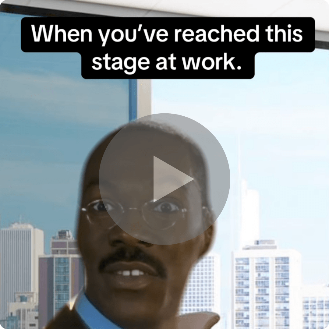 Text reads, “When you’ve reached this stage at work.” over a reaction shot of a man in an office with a city view behind him, with a play button overlay indicating a humorous video.