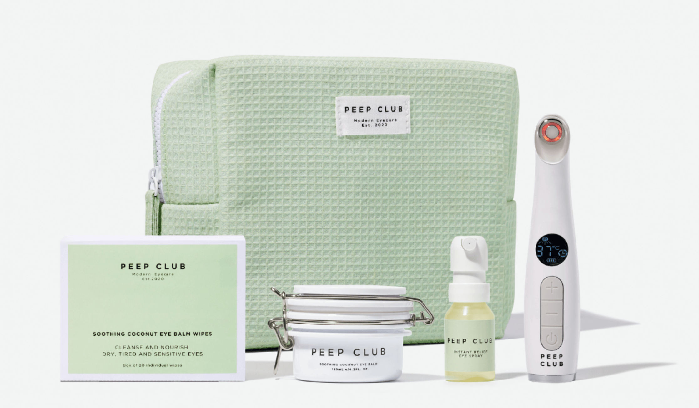A mint-green eye care gift set is arranged on a white background. The set includes a textured zippered pouch, a box of cleansing wipes, a jar of eye balm, a small spray bottle, and a handheld device with a digital display.