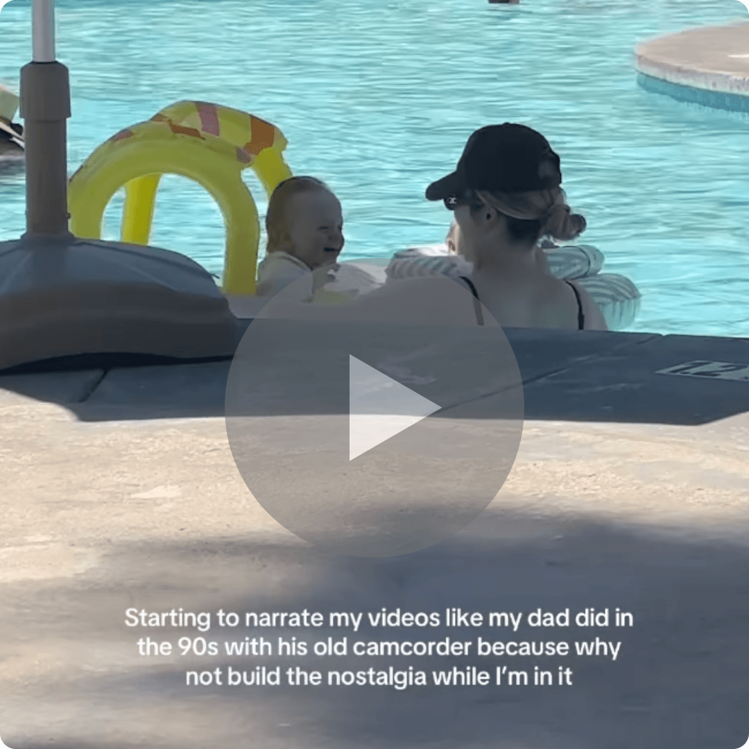 A parent and young child float together in a swimming pool on inflatable loungers. Text on the video thumbnail references bringing back the nostalgic camcorder-style narration popular in the 1990s.