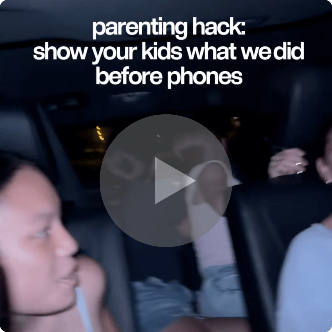 A video thumbnail shows children sitting inside a vehicle at night. White text at the top references a parenting hack, and a large play button overlays the center of the image.