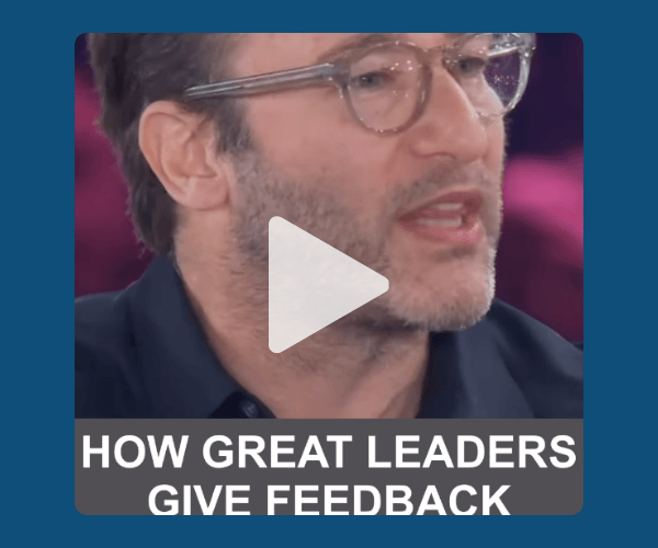 A video thumbnail shows a close-up of a man wearing glasses and speaking against a blurred background. A large play button appears in the center, with text at the bottom reading, “How Great Leaders Give Feedback.”