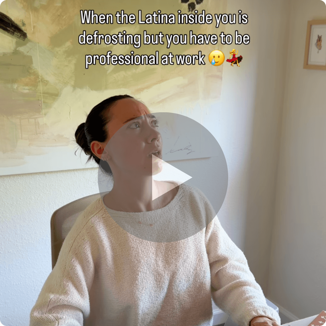 A video thumbnail shows a woman sitting at a desk with overlaid text about staying professional at work while her "Latina inside" is defrosting. A large play button appears in the center, and a framed artwork hangs on the wall behind her.