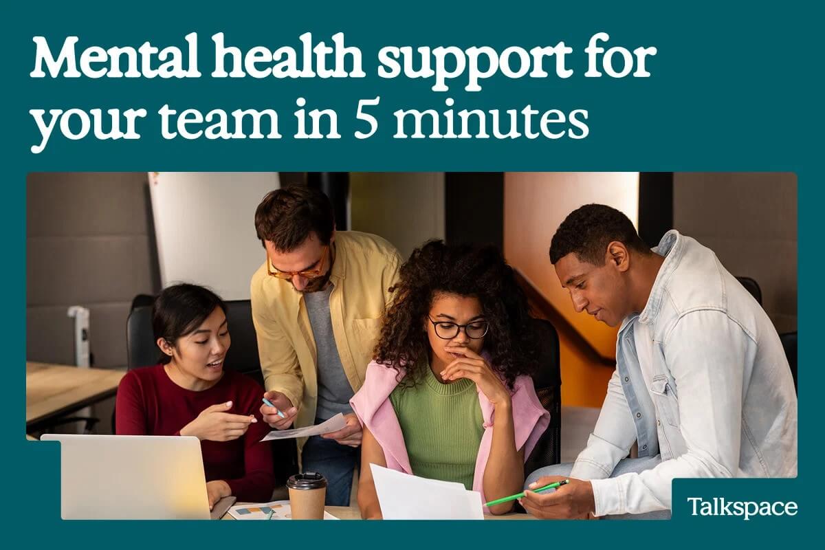 A promotional graphic shows four coworkers gathered around a table reviewing documents and working together in an office. Large text at the top reads "Mental health support for your team in 5 minutes," and the Talkspace logo appears in the bottom-right corner.