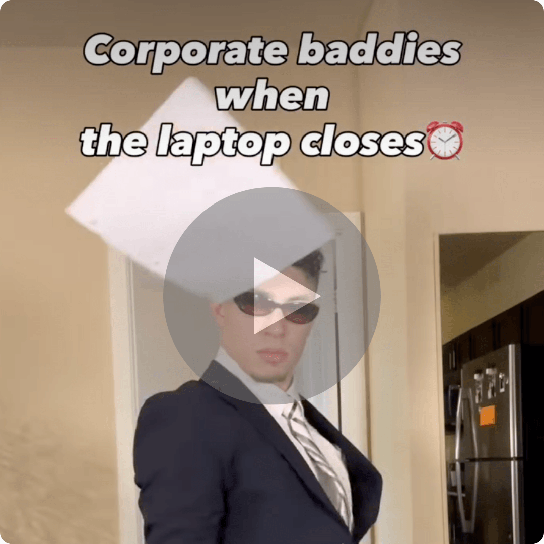 A person in a dark suit and sunglasses dramatically flips a laptop closed while standing indoors. Large text at the top reads, “Corporate baddies when the laptop closes,” followed by an alarm clock emoji.