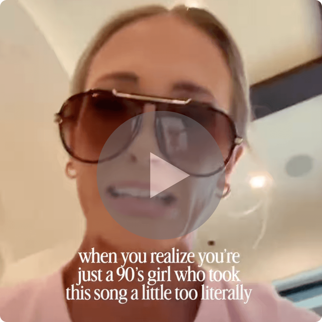 A video thumbnail shows a woman wearing oversized sunglasses indoors with overlaid text about being a '90s girl. A large play button appears in the center, and warm lighting is visible in the background.