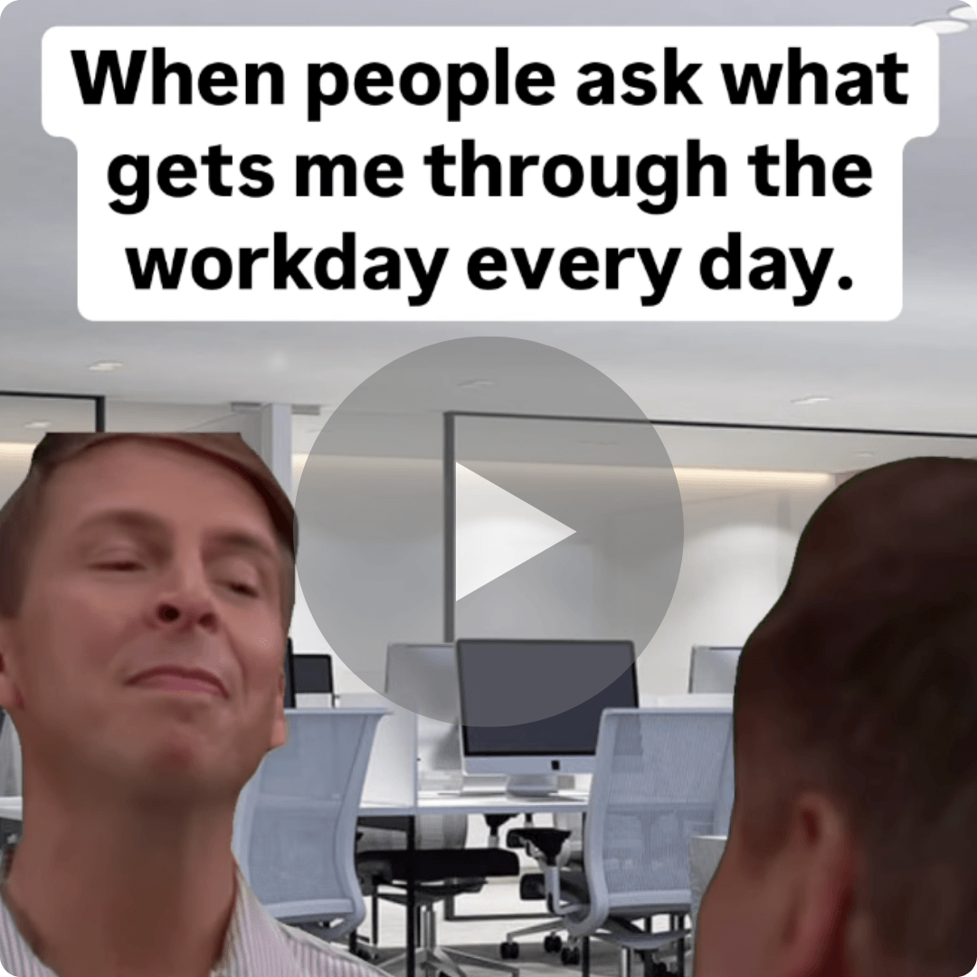 A workplace meme shows two men in a modern office with desks and computer monitors in the background. Text at the top reads, “When people ask what gets me through the workday every day.”