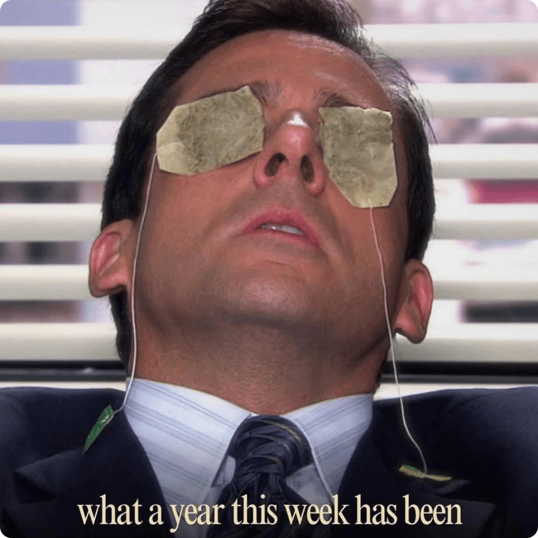 A man in a suit leans back with slices covering both eyes while wires hang down from his face. Text at the bottom reads, “what a year this week has been.”