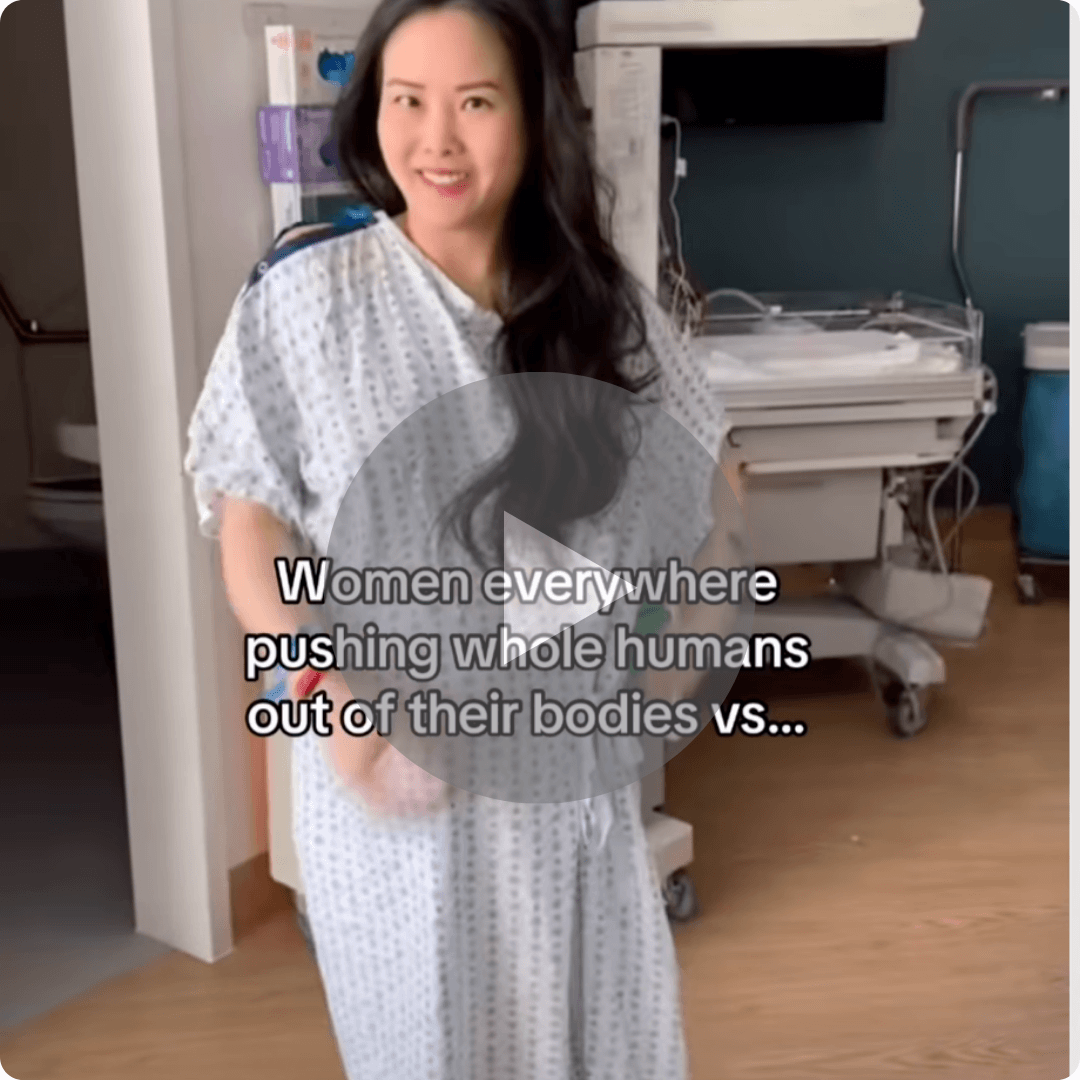 A video thumbnail shows a woman in a hospital gown standing in a maternity room with medical equipment behind her. A large play button overlays the image, with text reading, “Women everywhere pushing whole humans out of their bodies vs...”