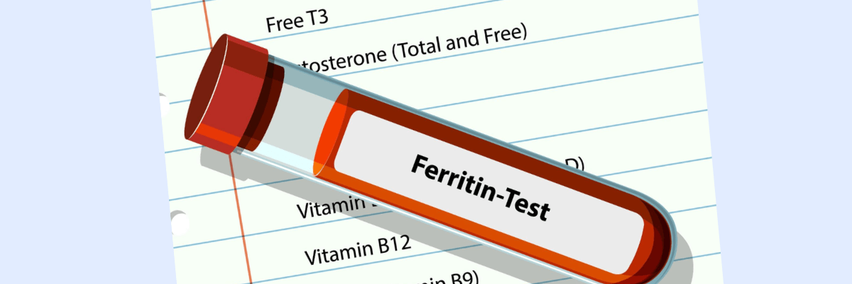An illustration of a blood sample tube labeled “Ferritin-Test” is placed diagonally over a blurred medical lab request form. The form includes partially visible entries such as Free T3, testosterone, vitamin D, and vitamin B12.