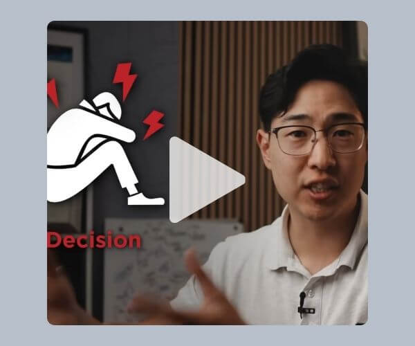 A man wearing glasses and a white shirt appears in a video frame. A graphic of a seated figure with red lightning symbols is shown on the left, with the word “Decision” near the bottom.