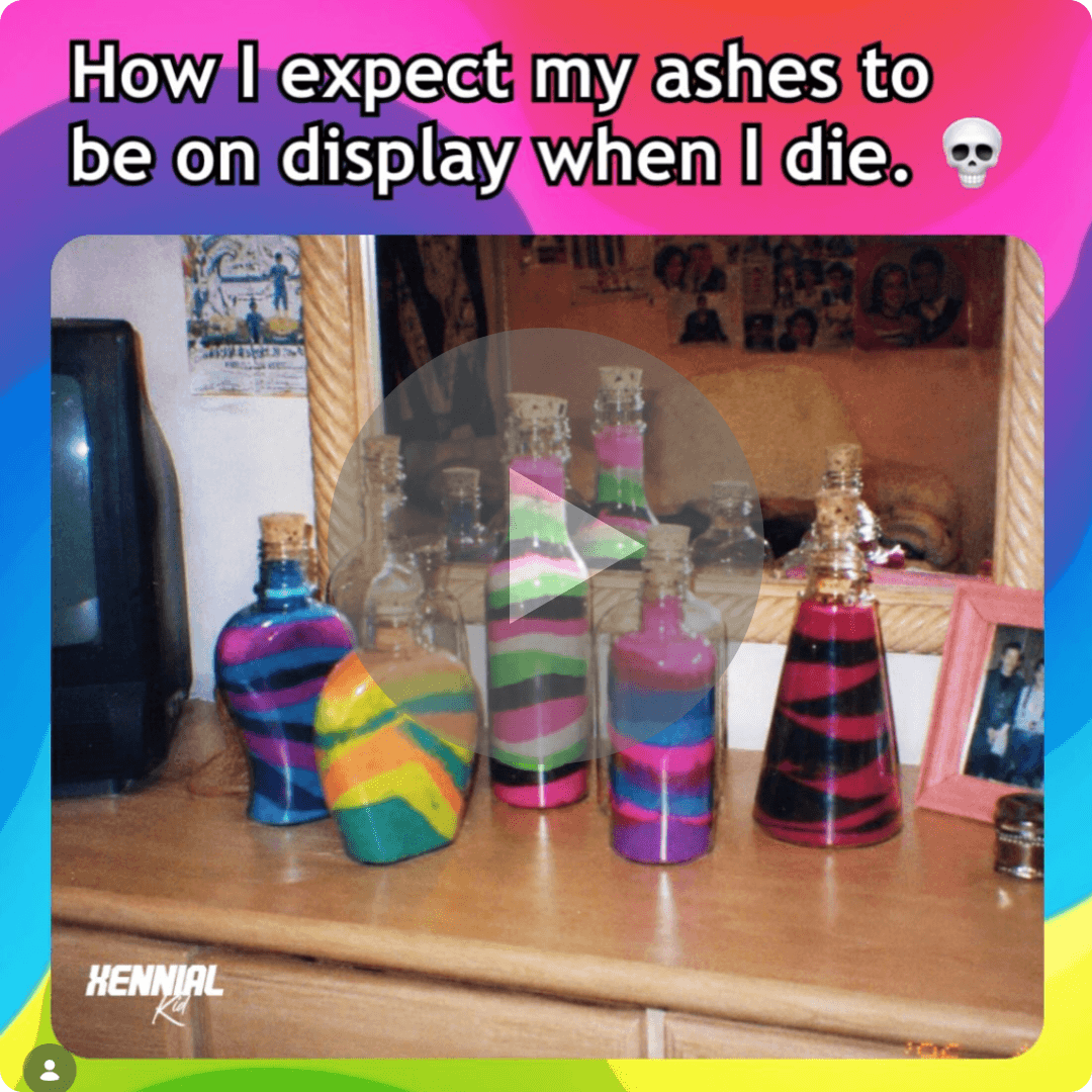 Several colorful glass bottles sit on a wooden dresser in front of a mirror. Large text at the top reads, “How I expect my ashes to be on display when I die.”