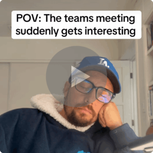A man in glasses and a blue cap rests his head on his hand. Text above him reads, “POV: The teams meeting suddenly gets interesting,” and a play button covers the center of the image.
